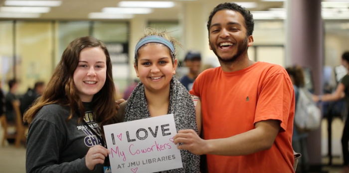 3 students holding sign saying "I love my coworkers at JMU Libraries"