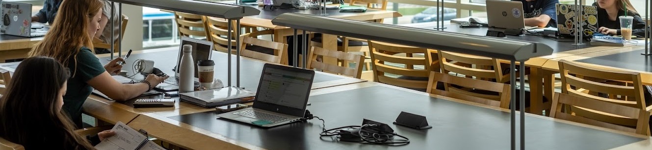 students with laptops in library study area