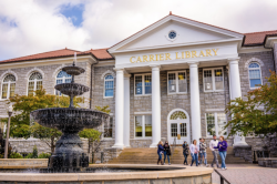 Carrier Library historic entrance, with fountain nearby, and a group of people in the middle distance
