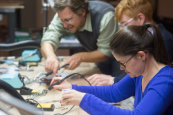 Photo of staff learning to use electronics at a workbench