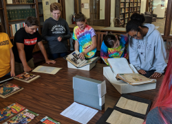 Local students with JMU's Valley Scholars program visiting the JMU Libraries Special Collections Reading Room. They are viewing comic books and other materials from our collections